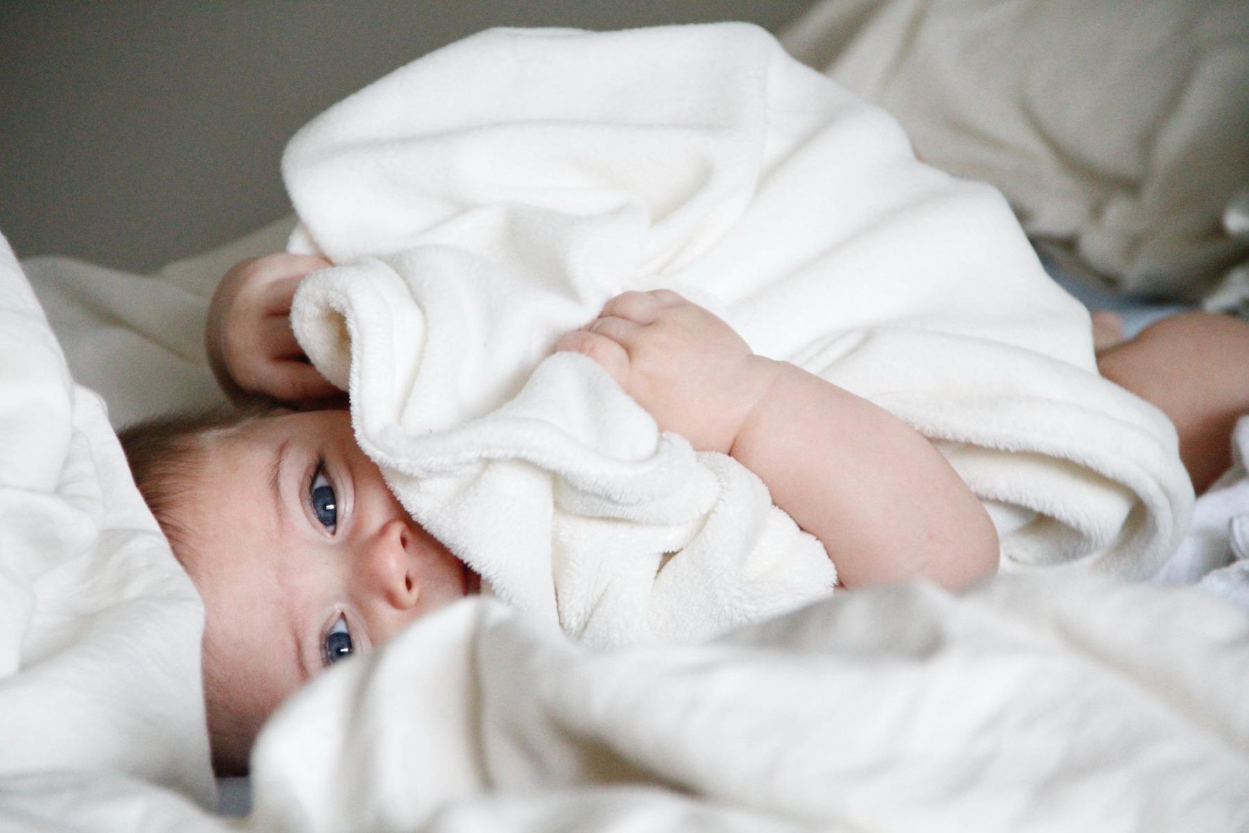 A baby wrapped in a white blanket