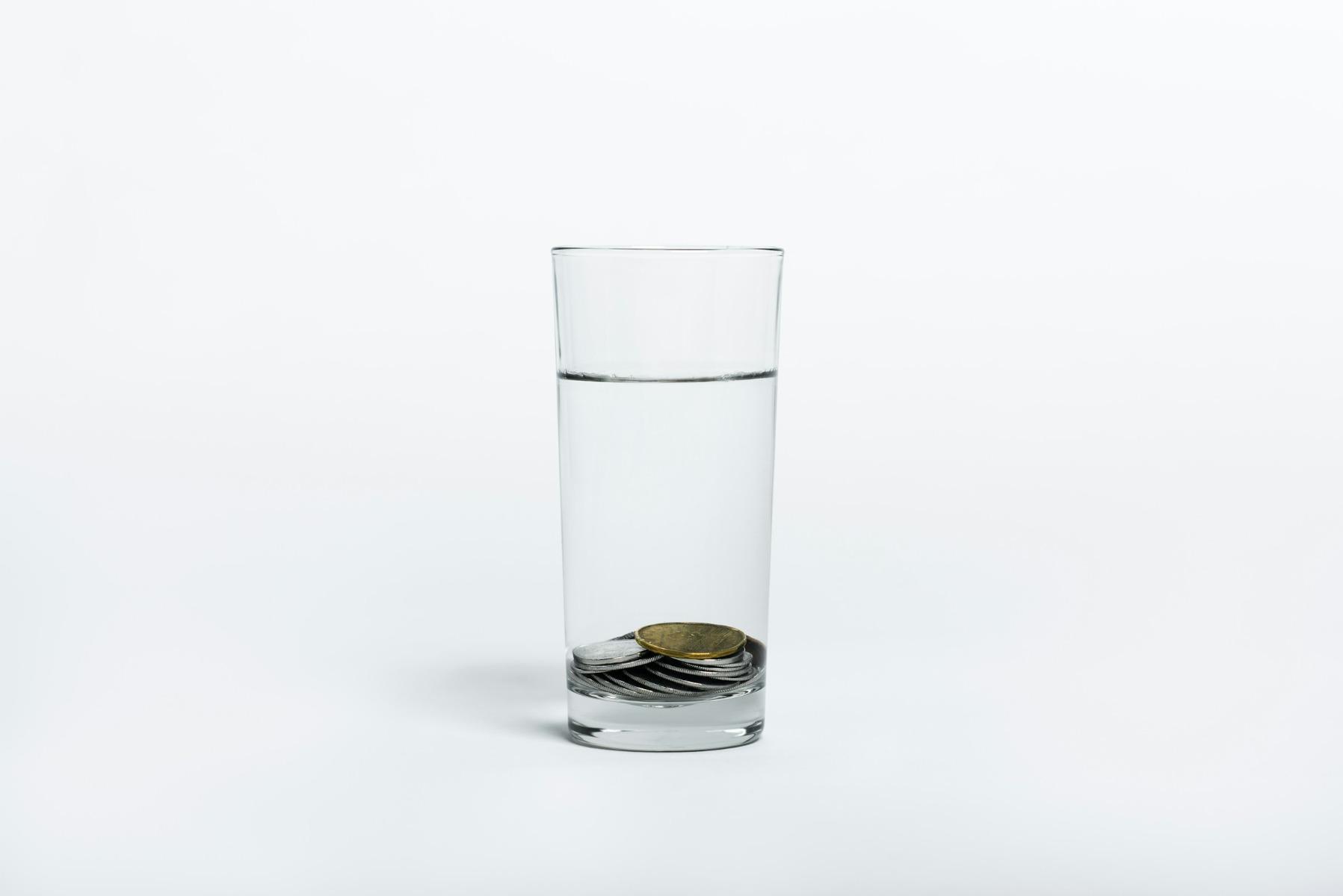 A glass of water with coins